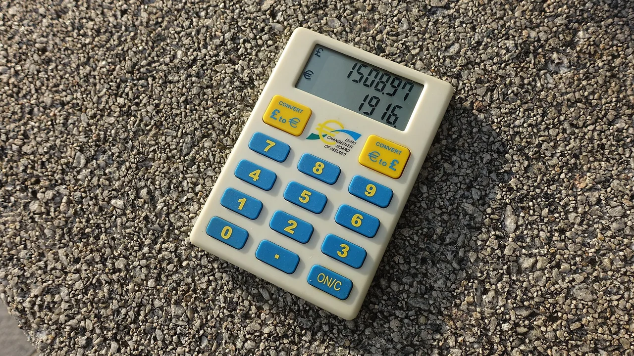 Calculadora e cédulas sobre uma mesa, representando o planejamento do crédito com garantia do FGTS