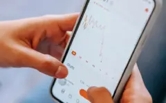 Pessoa segura um smartphone, representando a consulta de um benefício e de descontos de crédito no INSS.