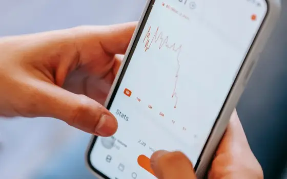 Pessoa segura um smartphone, representando a consulta de um benefício e de descontos de crédito no INSS.