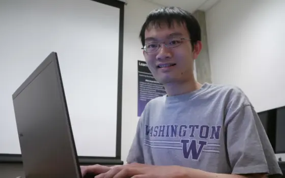 Estudante usa laptop para estudar em uma mesa, em imagem sobre o pagamento do Pé-de-Meia