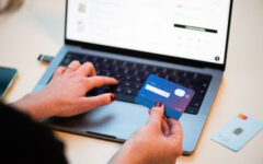 Pessoa usando cartão bancário para fazer uma compra online pelo celular