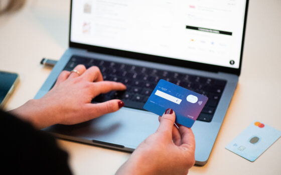 Pessoa usando cartão bancário para fazer uma compra online pelo celular