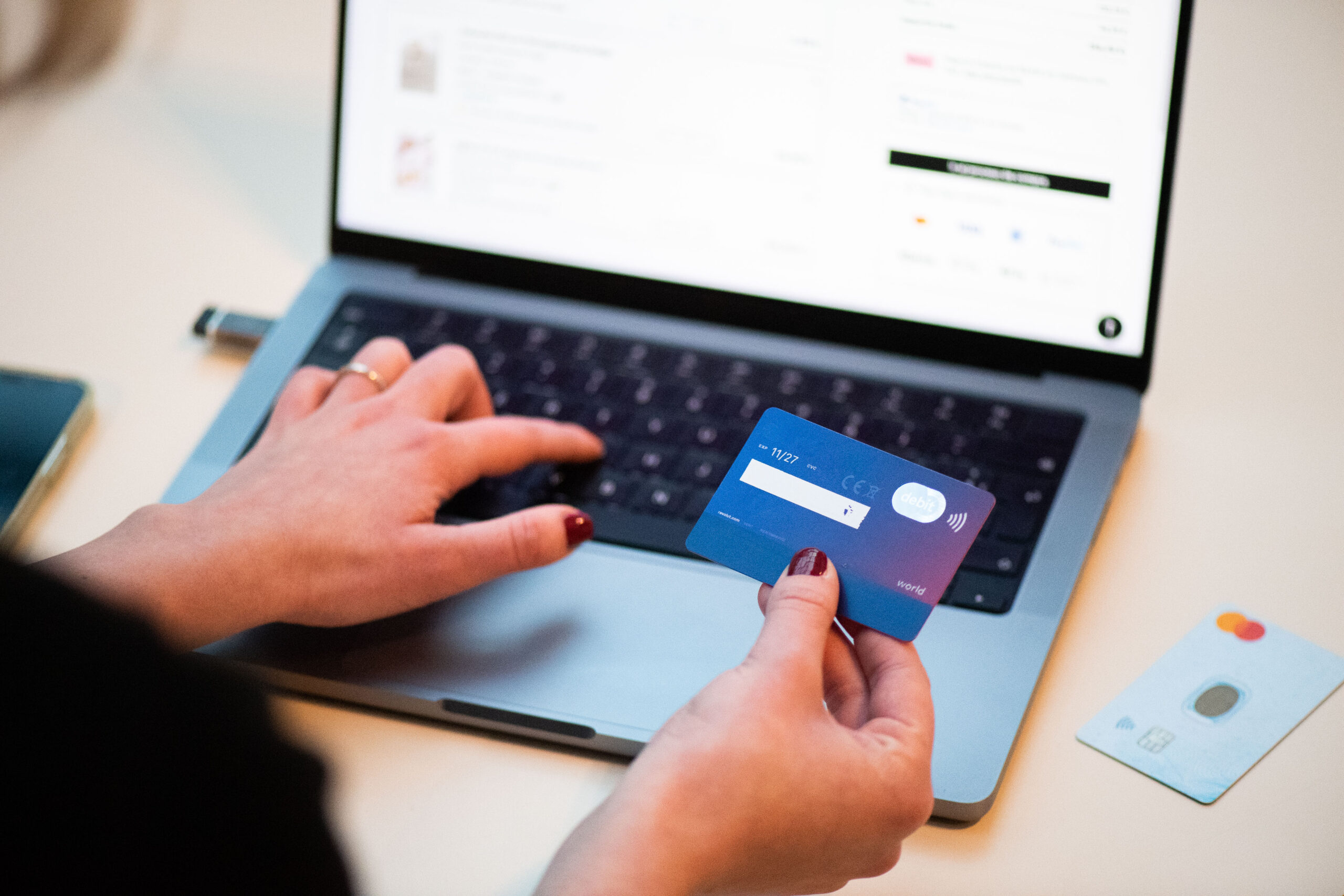 Pessoa usando cartão bancário para fazer uma compra online pelo celular