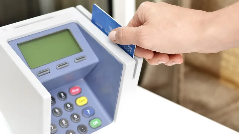 Cartão sendo usado em uma máquina de pagamento, em exemplo de serviço bancário