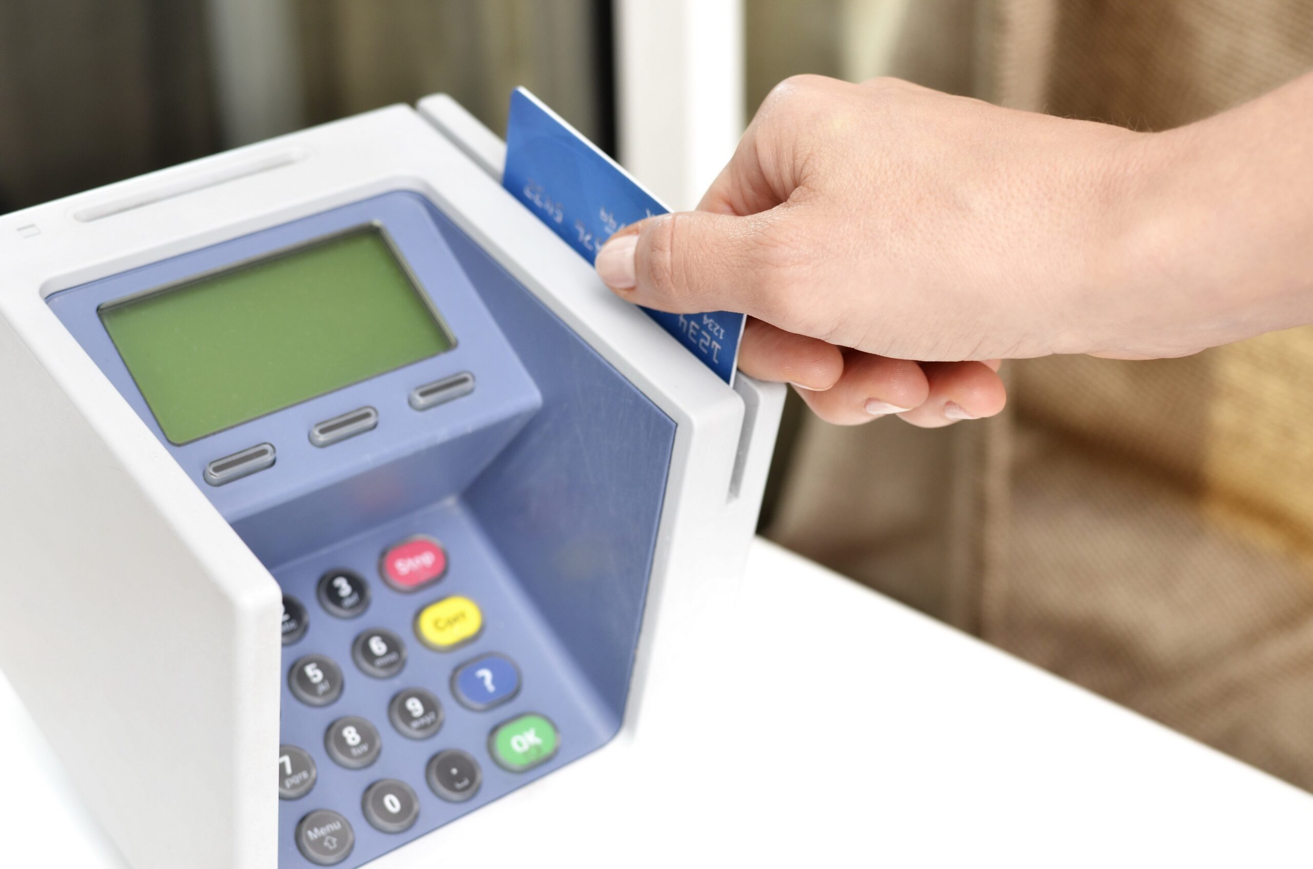Mão inserindo cartão de crédito em uma máquina de pagamento