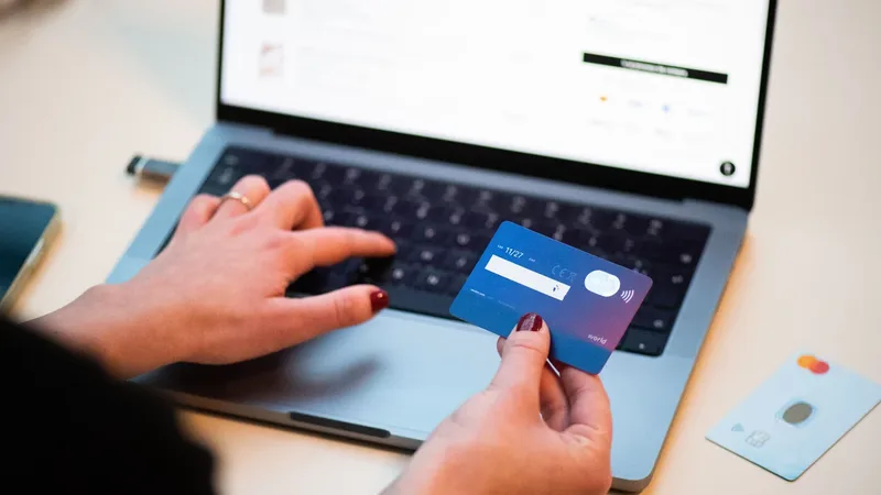 Pessoa usando cartão e celular para fazer uma compra online