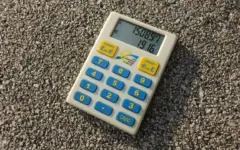 Calculadora e moedas sobre uma mesa, usadas para representar a análise de uma renegociação de dívida