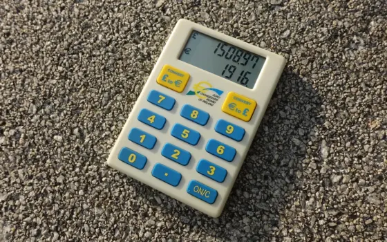 Calculadora e moedas sobre uma mesa, usadas para representar a análise de uma renegociação de dívida