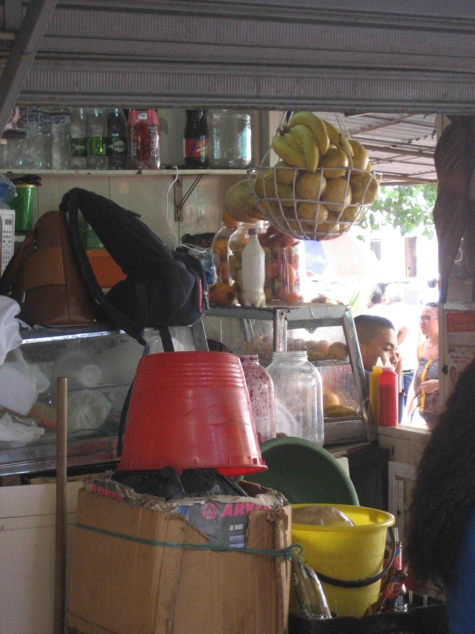 Interior de uma pequena loja de bairro, com prateleiras de produtos e balcão de atendimento.