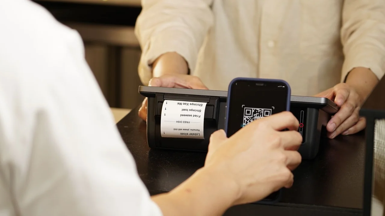 Pessoa apontando o celular para um código QR usado em uma cobrança