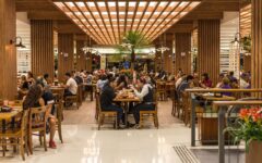 Corredor interno de shopping em São Paulo com lojas e circulação de consumidores