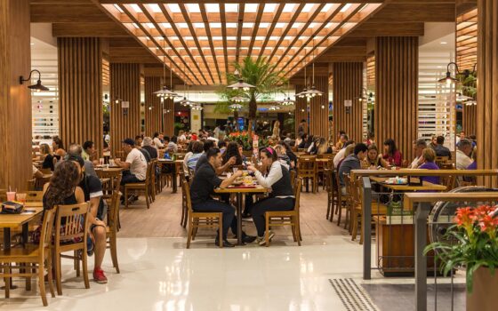 Corredor interno de shopping em São Paulo com lojas e circulação de consumidores