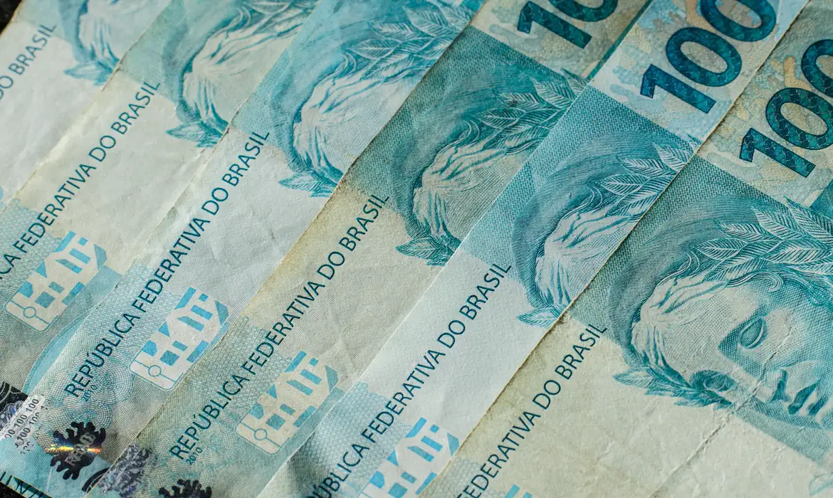 Cédulas de real sobre uma superfície, em imagem de contexto para investimentos do Tesouro Direto