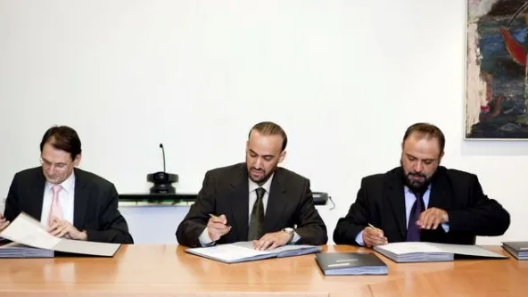 Contrato sendo assinado em uma reunião de trabalho