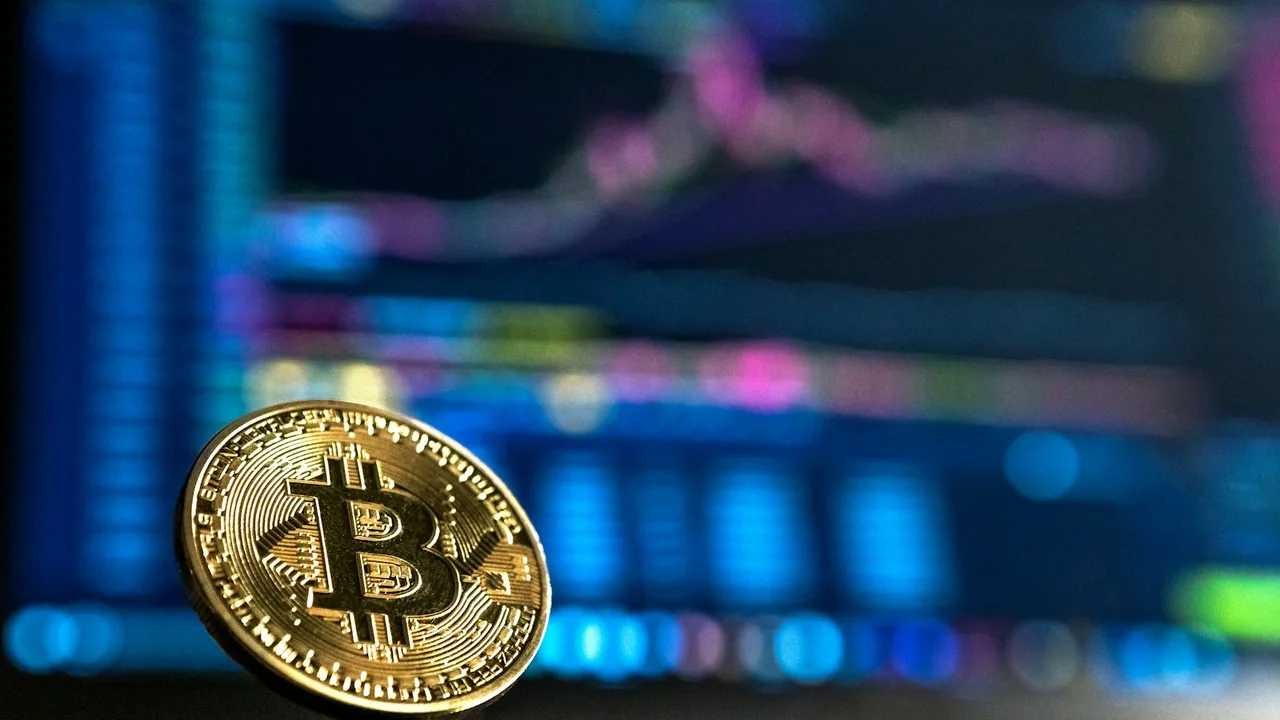 Moeda de Bitcoin diante de gráficos de mercado
