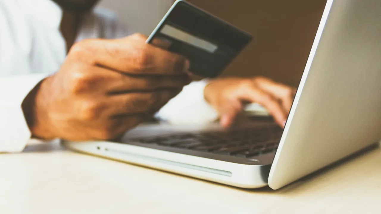 Pessoa usando cartão para fazer uma compra online