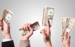Imagem destacada: mãos segurando cédulas, usada para representar dinheiro e investimento.