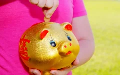 investimento para crianças: criança guardando dinheiro em cofrinho