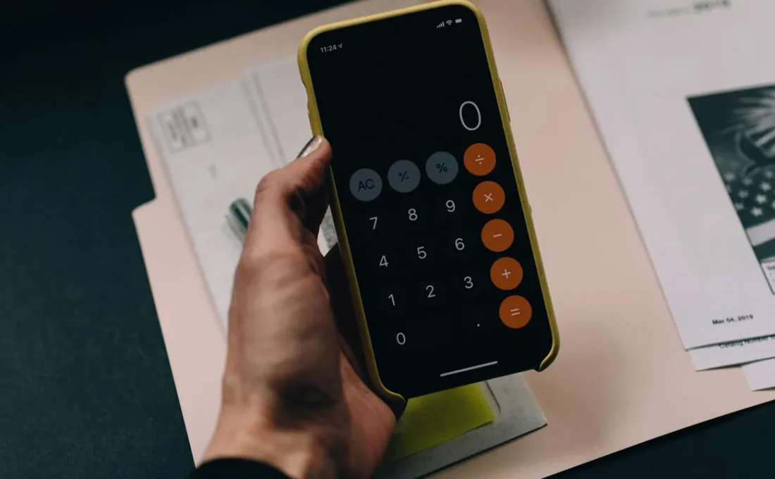Pessoa usando uma calculadora no celular para organizar o salário