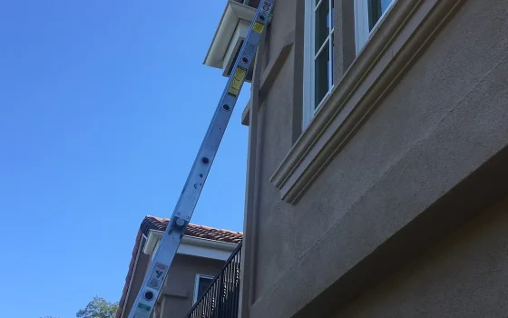 Escada apoiada na fachada de um prédio para trabalho em altura