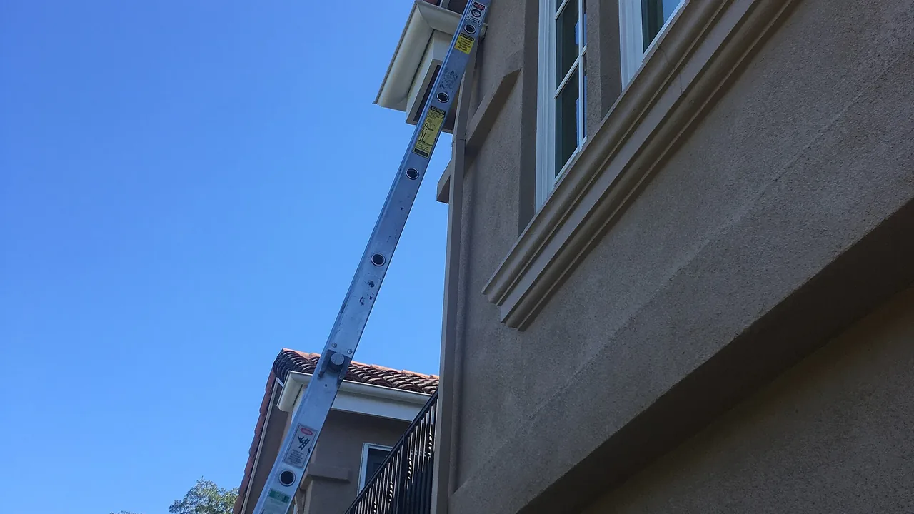 Escada apoiada na fachada de um prédio para trabalho em altura