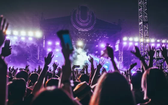 Público em um show com celulares erguidos diante do palco