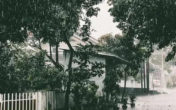 Rua residencial durante chuva forte e alagamento
