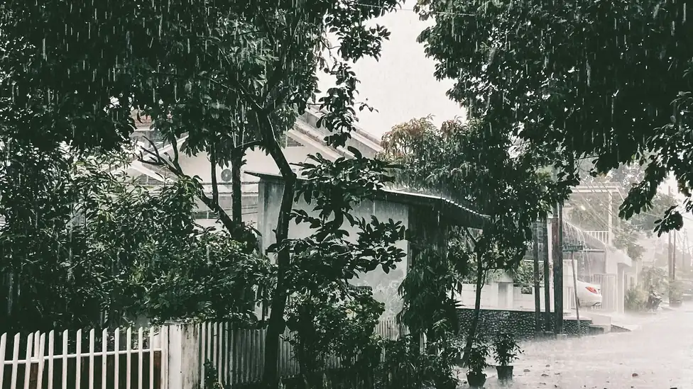 Rua residencial durante chuva forte e alagamento