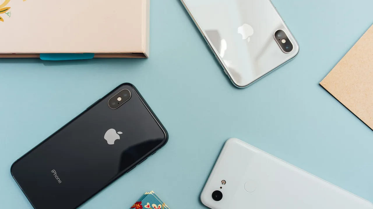Três celulares sobre uma mesa azul