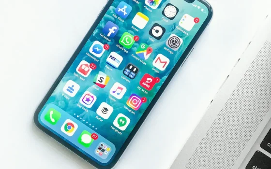 Celular sobre uma mesa ao lado de um laptop