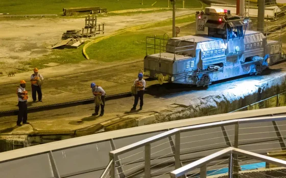 Trabalhadores em atividade noturna junto a uma locomotiva iluminada