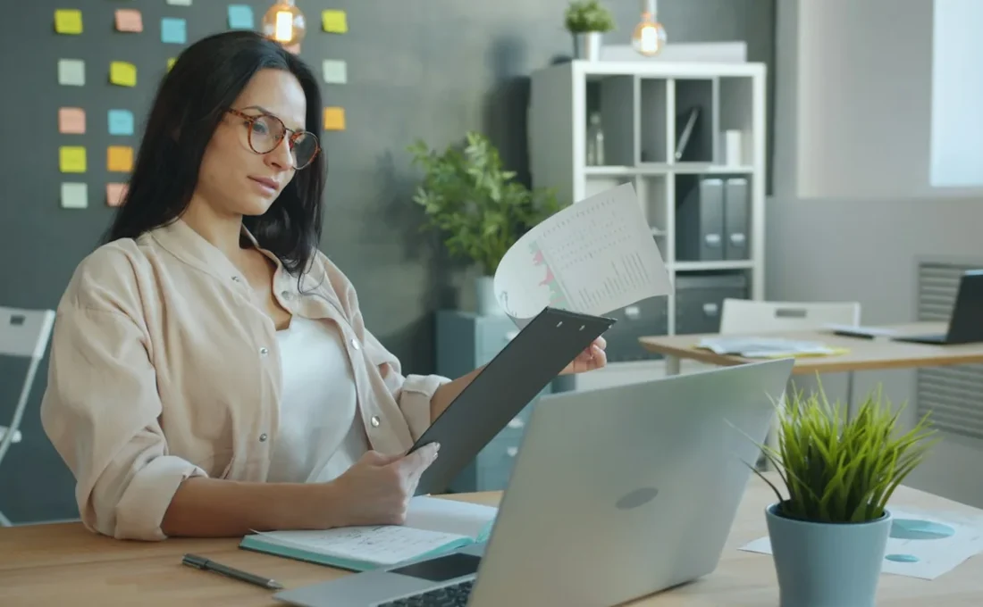 Profissional conferindo documentos e agenda em uma mesa de trabalho