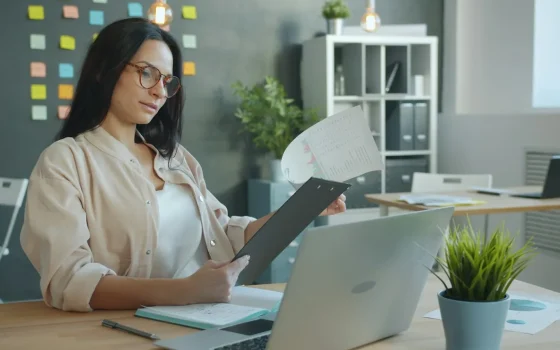 Profissional conferindo documentos e agenda em uma mesa de trabalho