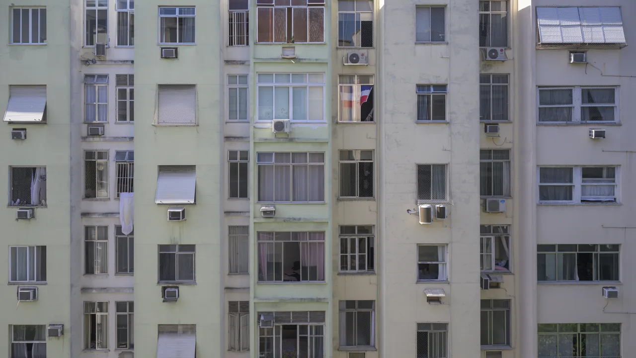 Fachada de prédio residencial com janelas e aparelhos de ar-condicionado