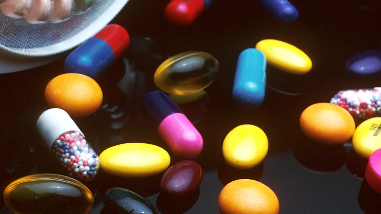 Cartelas e cápsulas de medicamentos sobre uma superfície escura