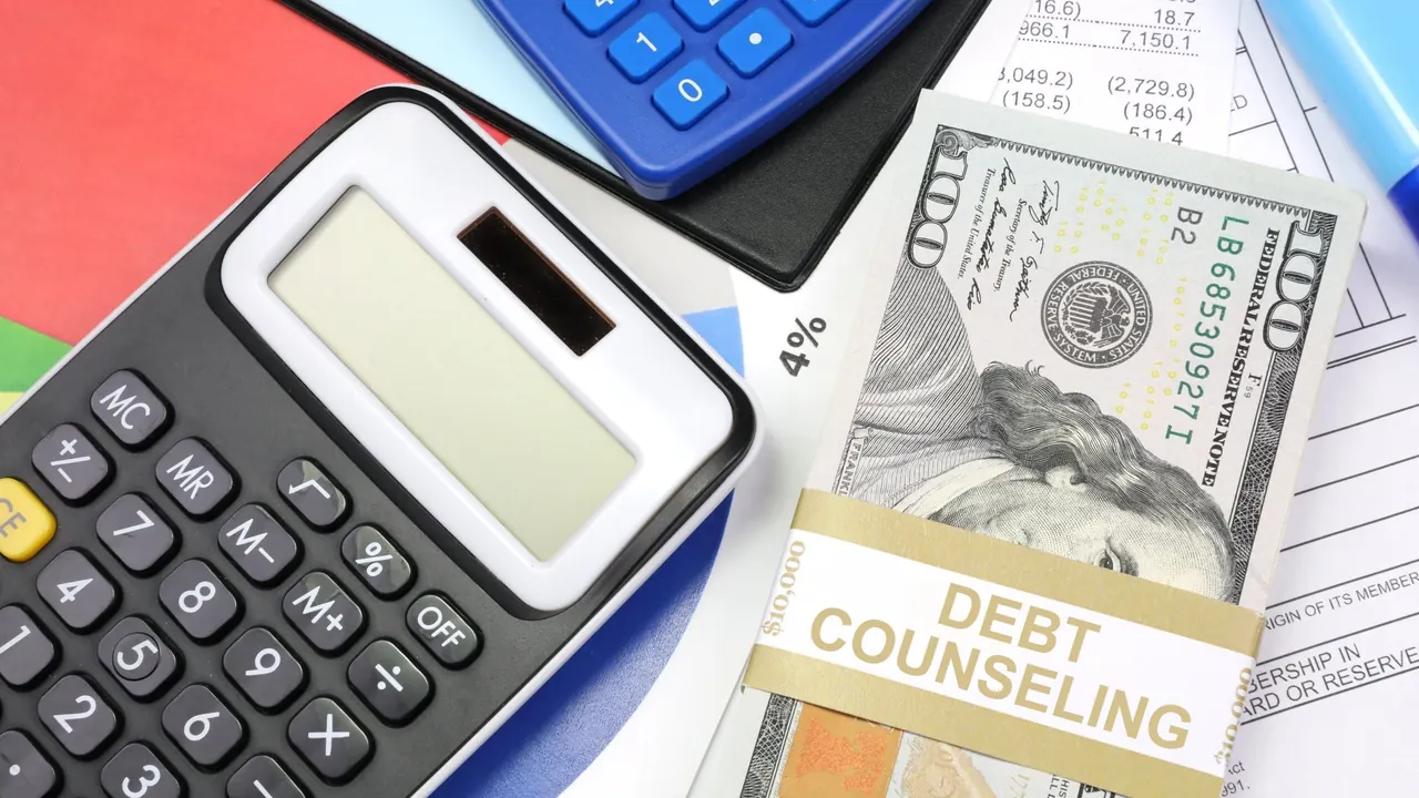 Calculadoras e cédula ao lado de documentos sobre aconselhamento de dívidas