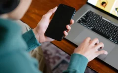 Pessoa usando celular e laptop ao mesmo tempo