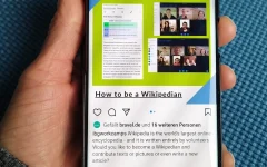 Mão segura um smartphone com conteúdo exibido na tela