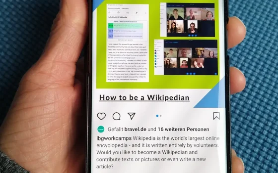 Mão segura um smartphone com conteúdo exibido na tela