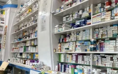 Prateleiras de uma farmácia com caixas de medicamentos