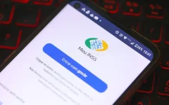 Celular com a tela de entrada do aplicativo Meu INSS sobre um teclado