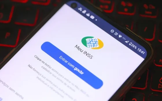 Celular com a tela de entrada do aplicativo Meu INSS sobre um teclado
