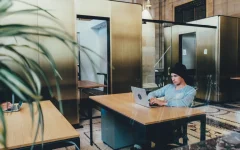Pessoa trabalhando em um escritório compartilhado com notebook