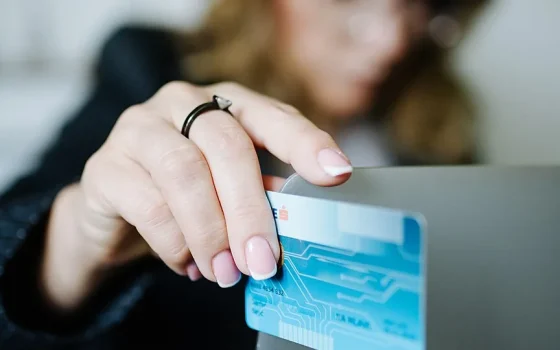 Pessoa usando cartão em compra online no laptop