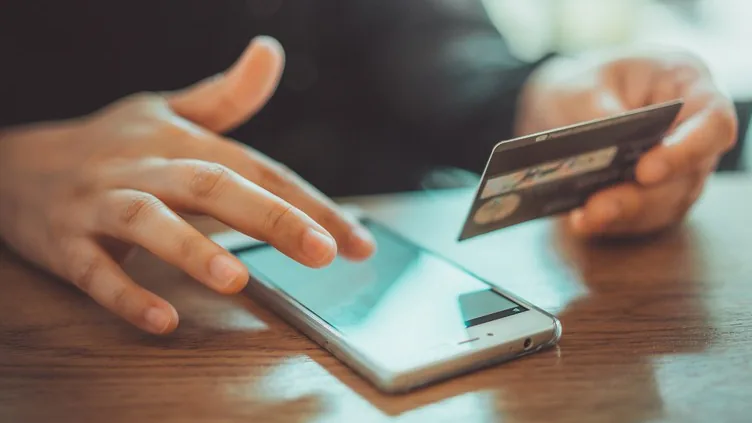 Celular e cartão usados como representação de dados bancários para restituição
